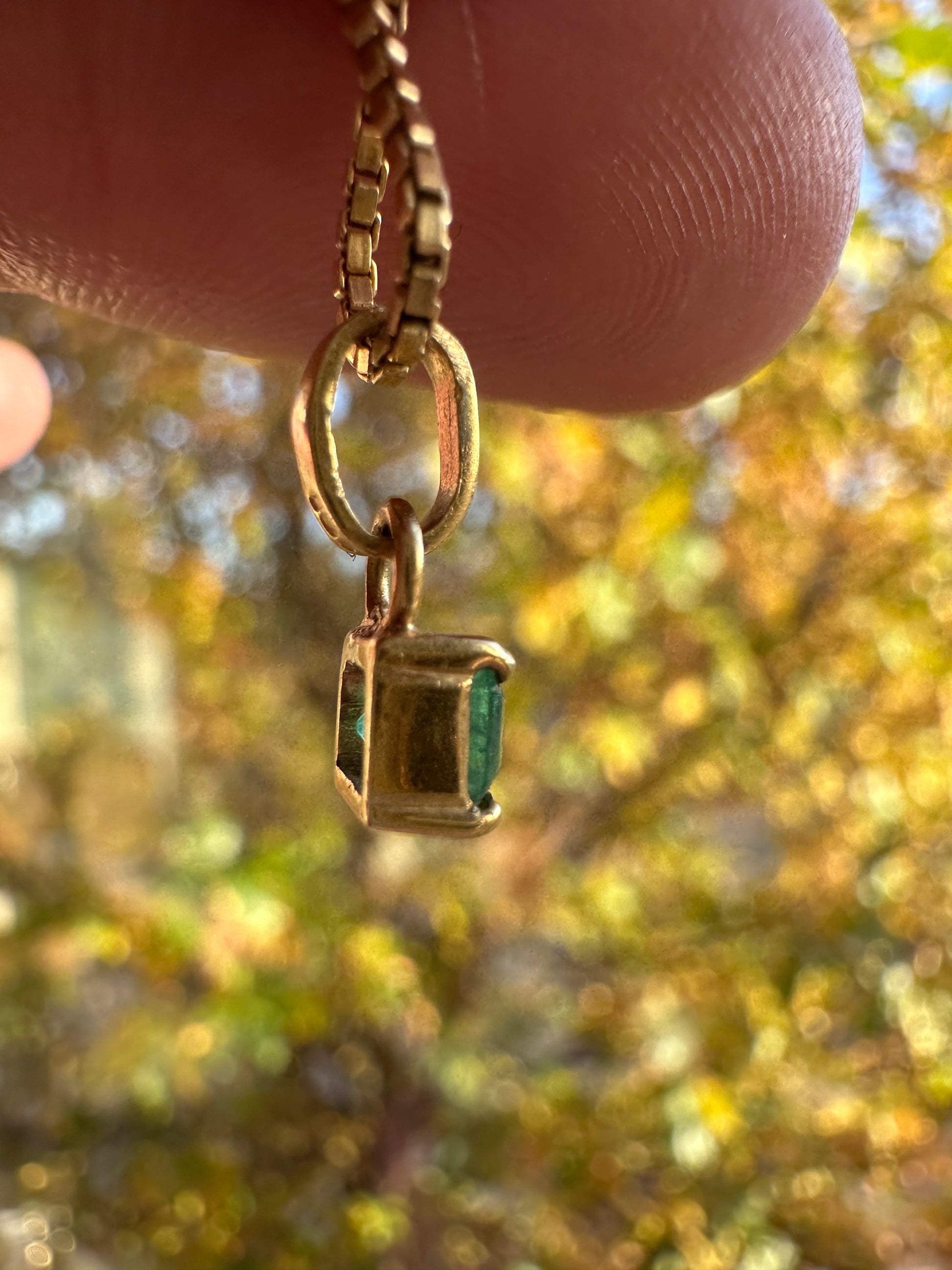 step cut square emerald and 18k gold charm
