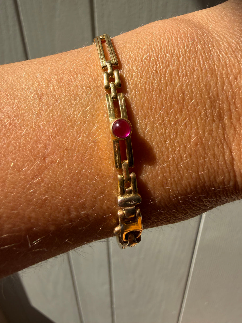 18k gold open bar link bracelet with ruby cabochon