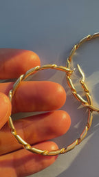 2" solid gold hoops with ribbon design